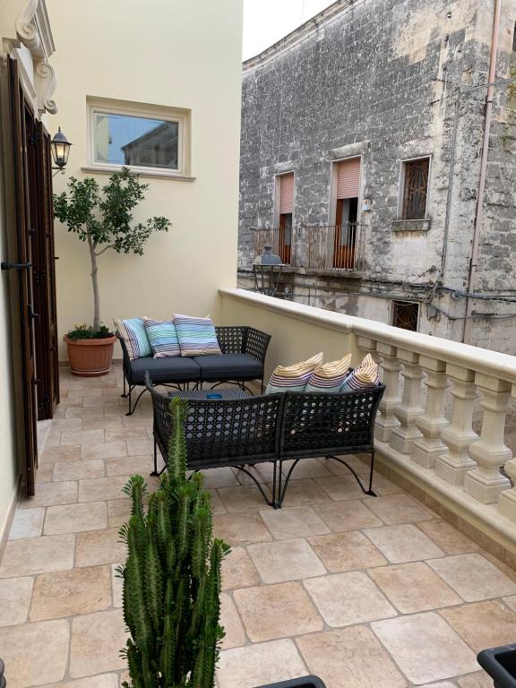 un patio con 2 sillas y una mesa en el balcón en Corcioli B&B, en Mesagne