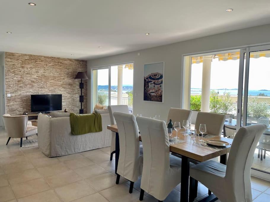 a dining room and living room with a table and chairs at Spacieux apt à proximité du port: clim et parking in Bandol