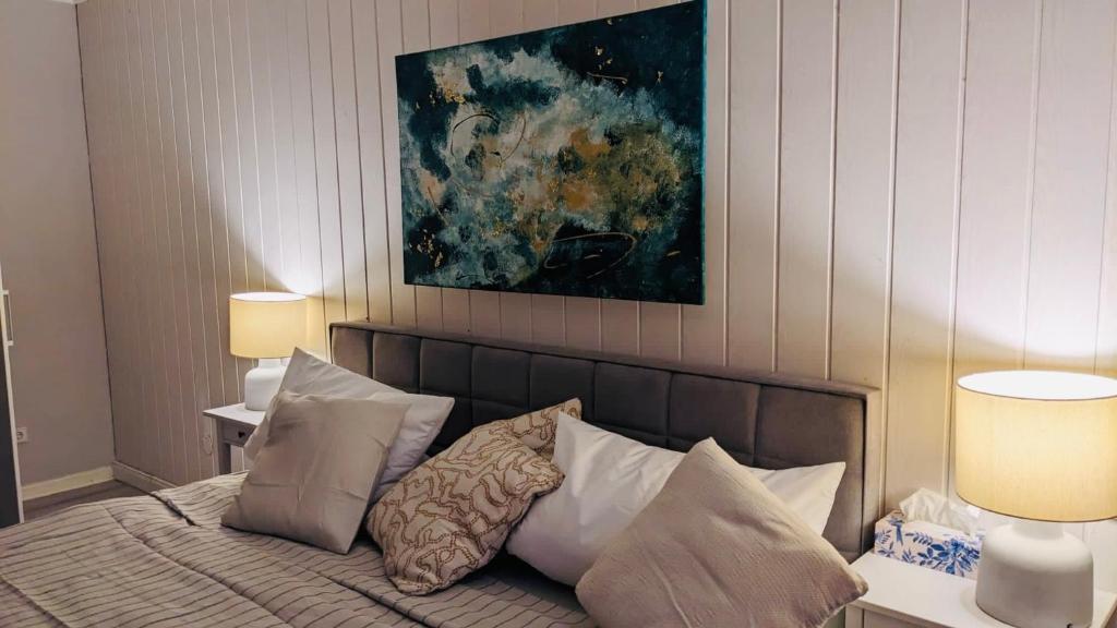 ein Schlafzimmer mit einem Bett mit Kissen und einem Gemälde in der Unterkunft Ferienhaus - b42936 in Schotten