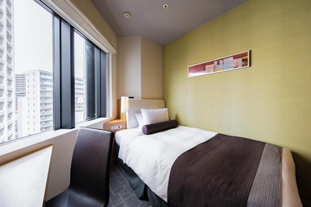 a hotel room with a bed and a large window at Tokyu Stay Kamata - Tokyo Haneda in Tokyo
