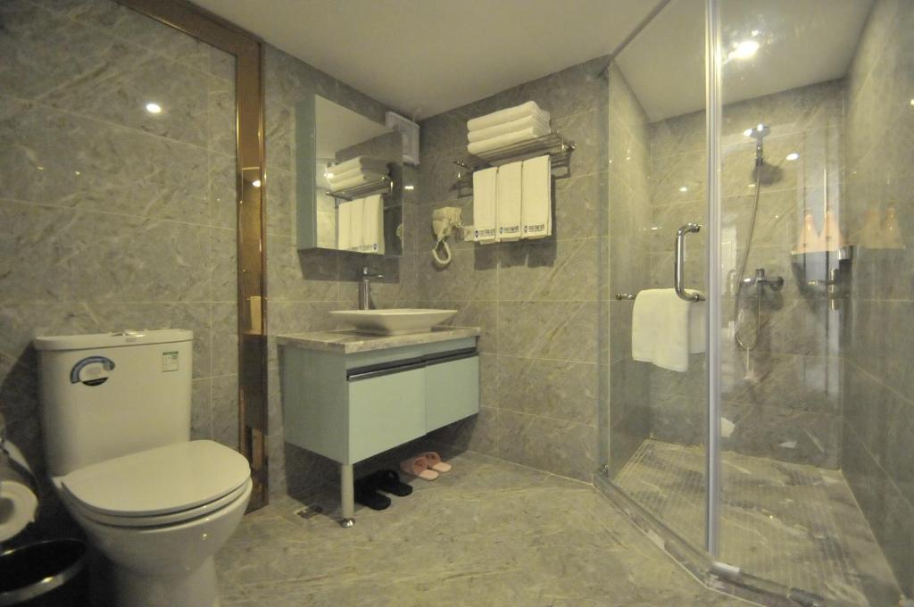 a bathroom with a toilet and a sink and a shower at WAIFIDEN Duplex Hotel Apartment Zhongyong Jinyu Branch-Free shuttle bus during the Canton Fair in Guangzhou