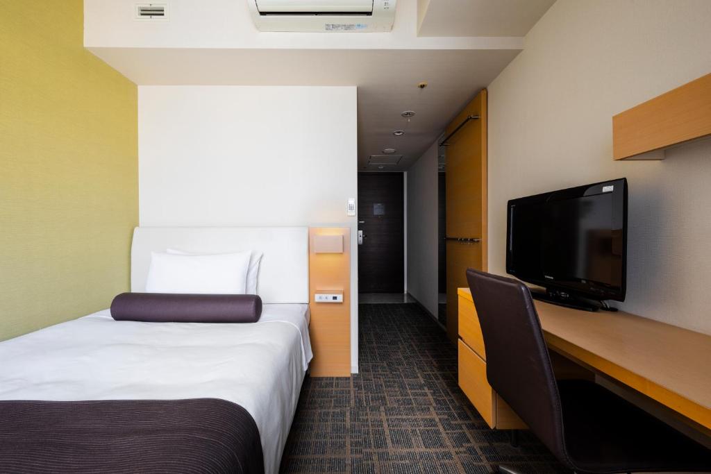 a hotel room with a bed and a desk and a tv at Tokyu Stay Kamata - Tokyo Haneda in Tokyo