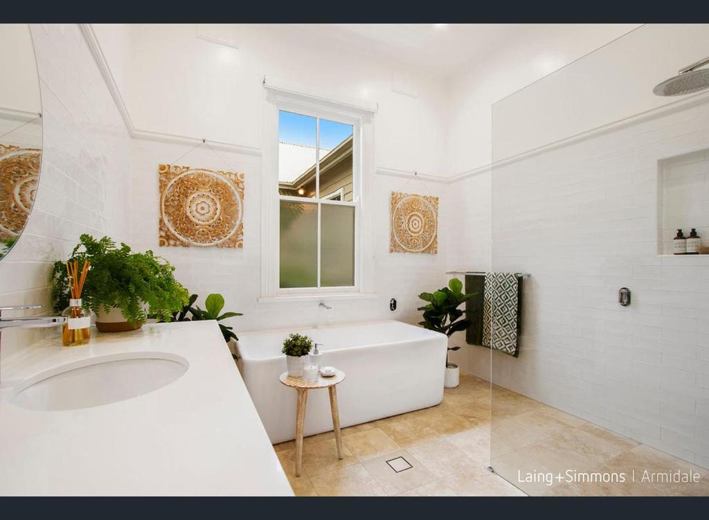 Baño blanco con bañera y lavamanos en Armidale Elegance en Armidale