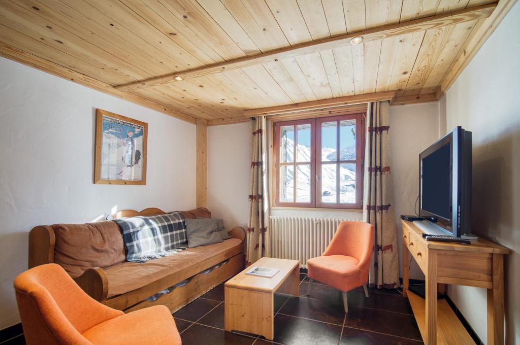 Una sala de estar con un sofá y un televisor. en Appartement Petite Charline, en Tignes