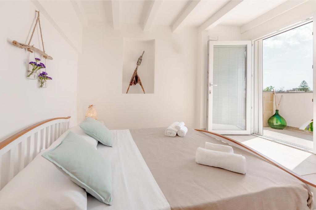 a white room with a bed and a window at Cala Cala Rooms,Restaurant & Farm Experience in Procida