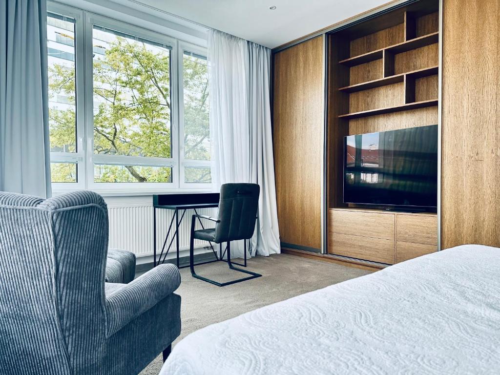 a bedroom with a bed and a chair and a desk at BEBA apartment in Košice