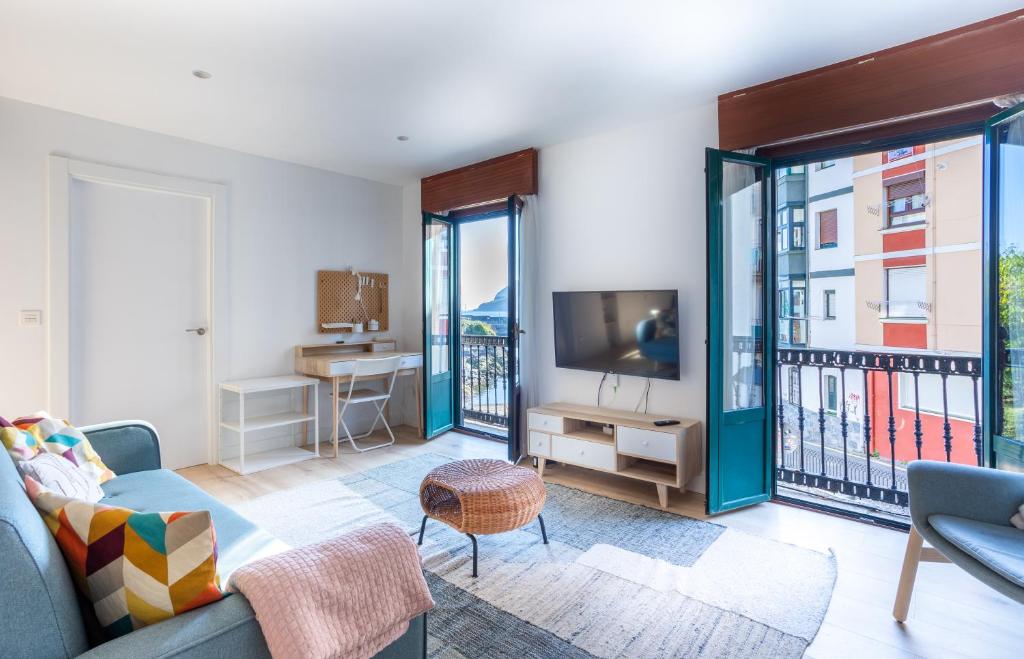 a living room with a couch and a tv at MUNDAKA Old Port in Mundaka
