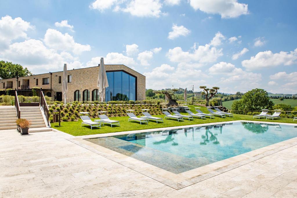 Villa con piscina y tumbonas en Country House Oliveto sul Lago, en San Nicolò