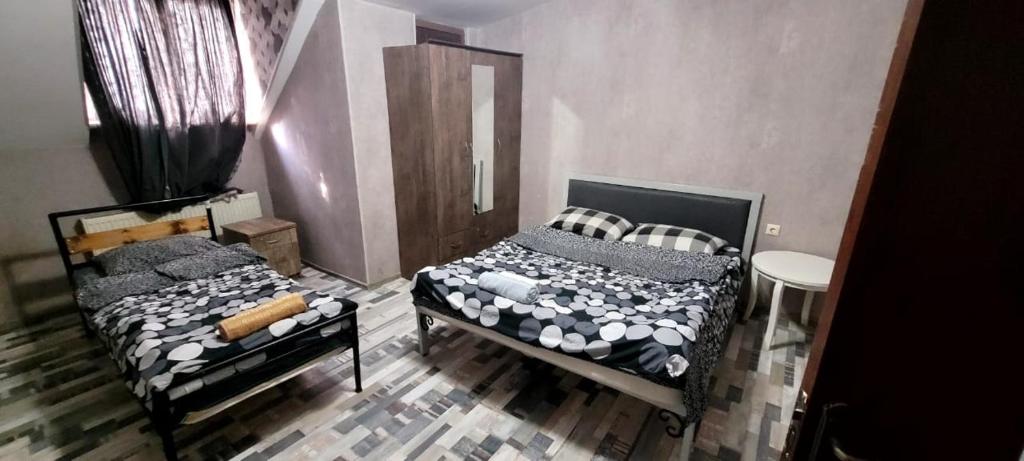 a bedroom with two beds and a mirror at Kiev hotel in Tbilisi City