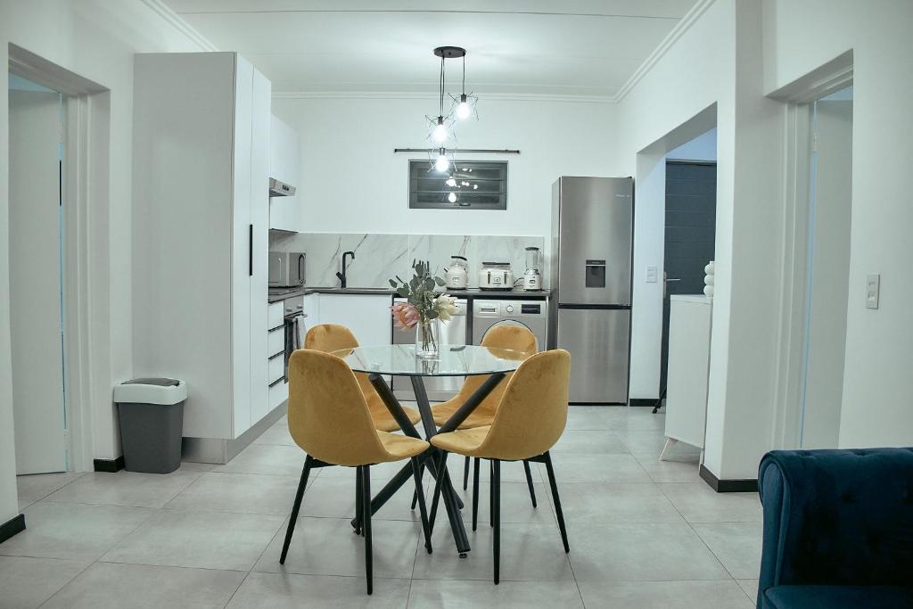 a dining room with a table and chairs in a kitchen at Medon Luxury Suites with power back up Bryanston Sandton in Johannesburg