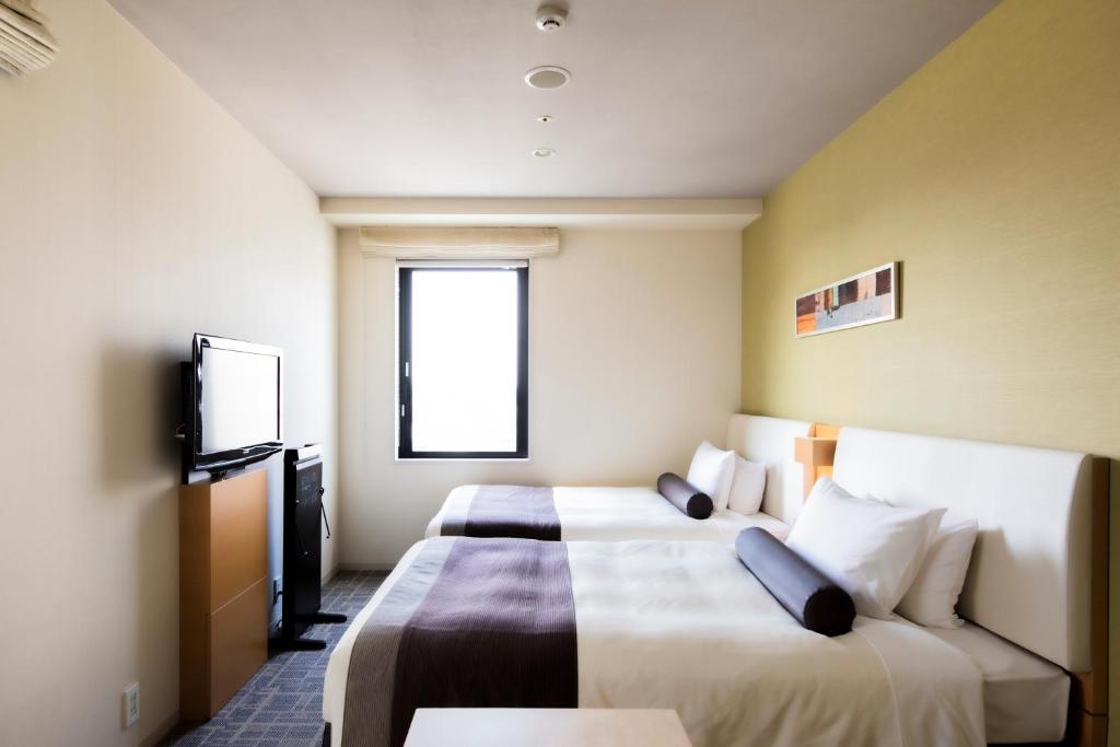 a hotel room with two beds and a tv at Tokyu Stay Kamata - Tokyo Haneda in Tokyo