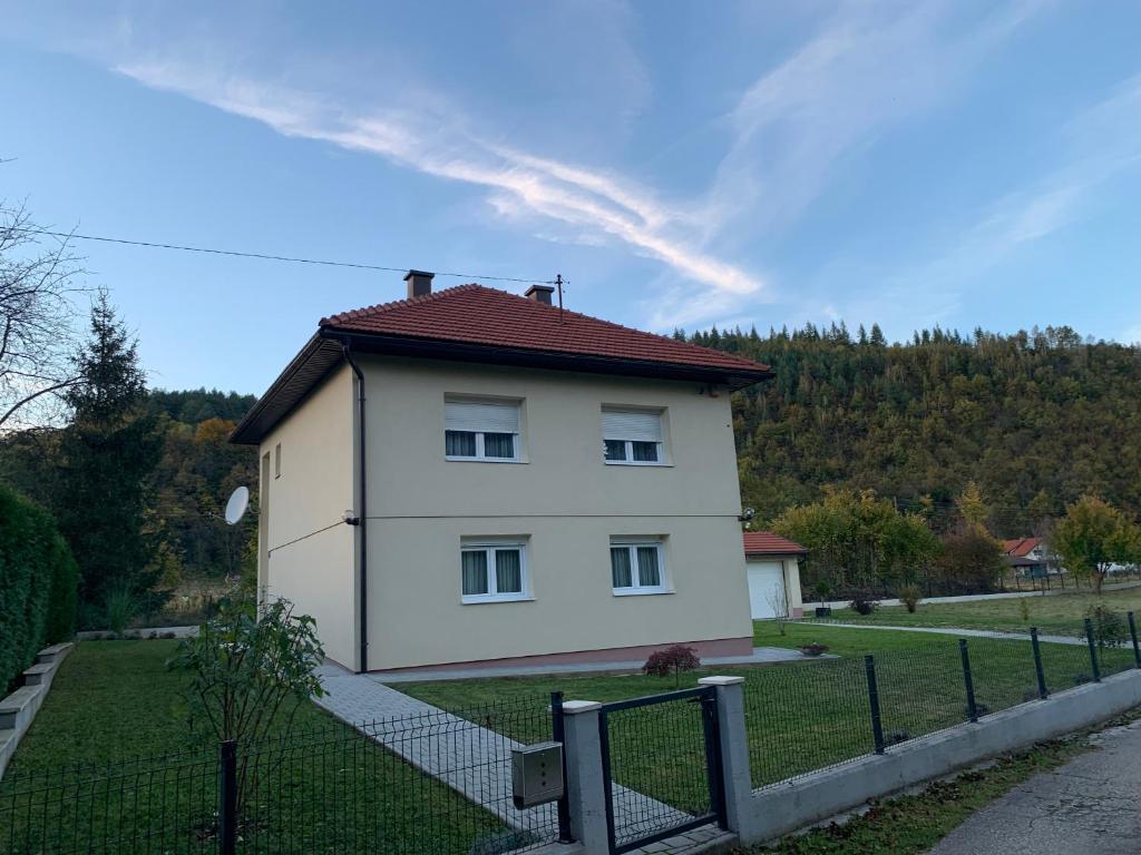 uma pequena casa branca com um telhado vermelho em Apartman BAGI em Kiseljak