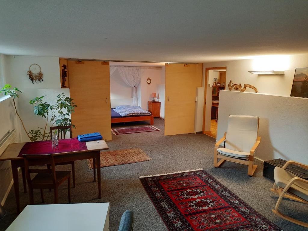 sala de estar con mesa y dormitorio en grosses Zimmer mit Küche/Du/WC zur Alleinnutzung en Kappel am Albis