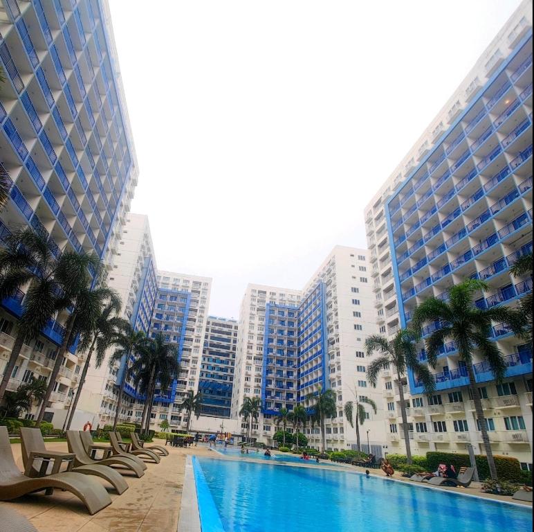 a pool in the middle of a city with tall buildings at Sea Residences by Jan & Val Alano in Manila