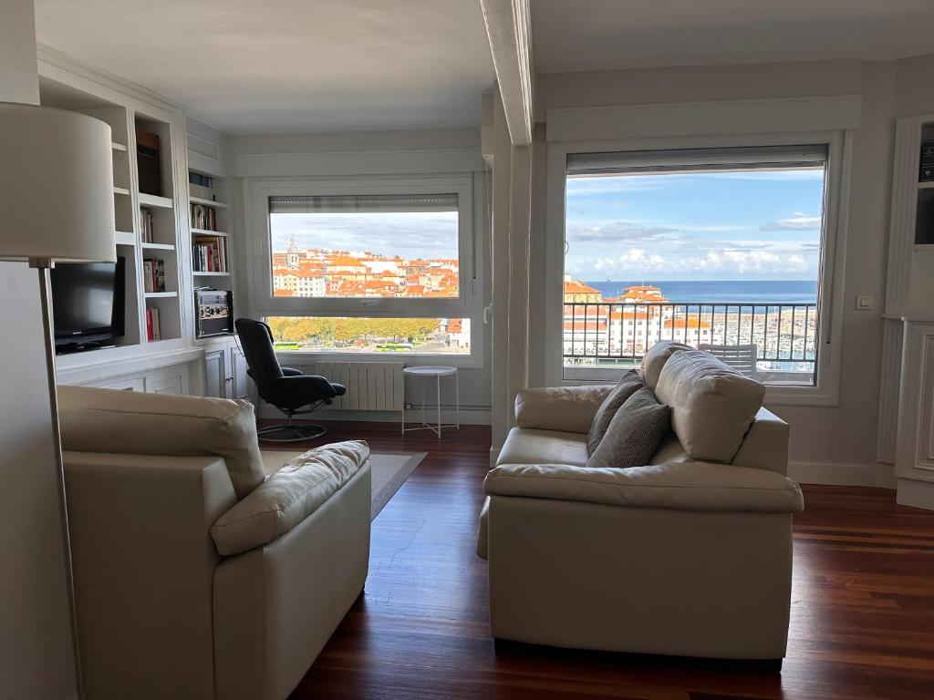 una sala de estar con 2 sofás y vistas al océano. en Apartxibi, en Bermeo