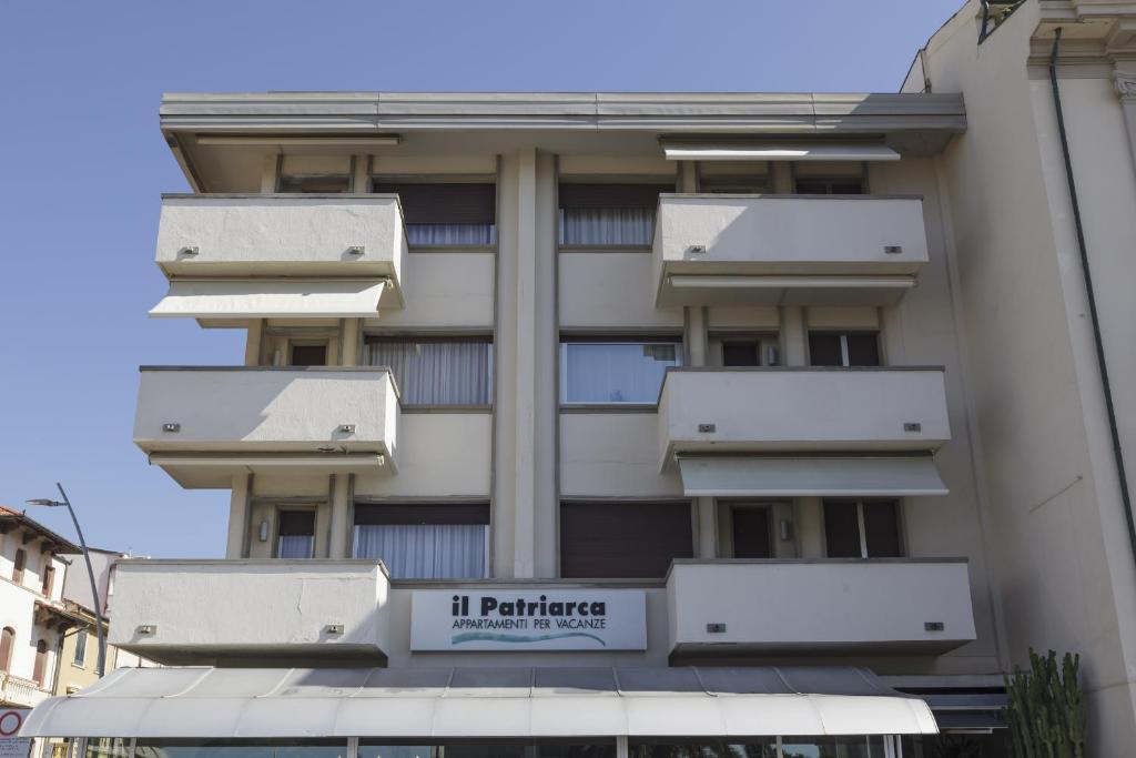 un edificio con balconi bianchi e un cartello sopra di Residence Il Patriarca a Viareggio