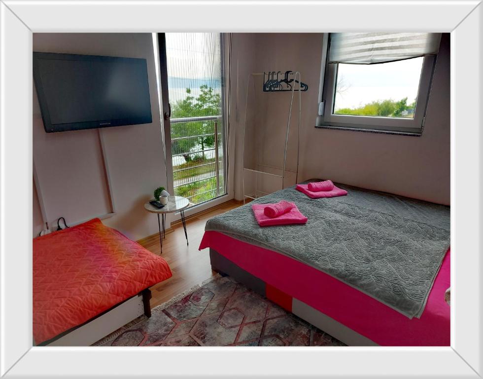 a bedroom with a bed and a flat screen tv at APARTMENT ANA v-Peshtani in Ohrid
