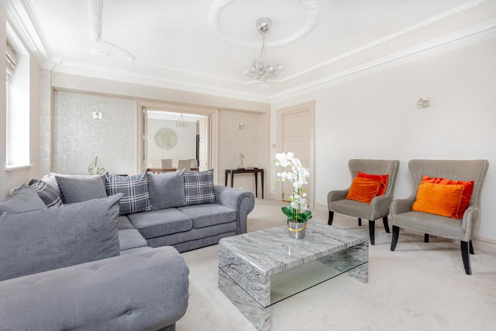 a living room with a couch and chairs and a table at Exceptional 3BDR flat in Mayfair in London