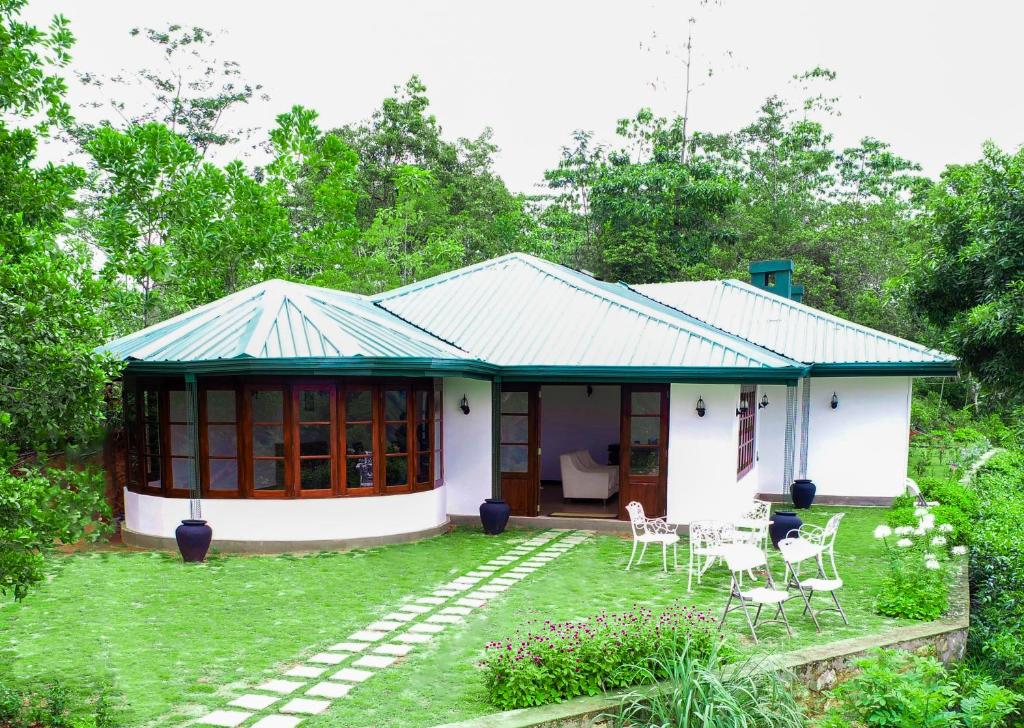 a small white house with a green roof at Kobbekaduwa Bungalow in Kandy