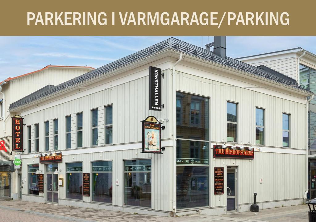 a white building with a sign on the front of it at Hotel Bishops Arms Piteå in Piteå