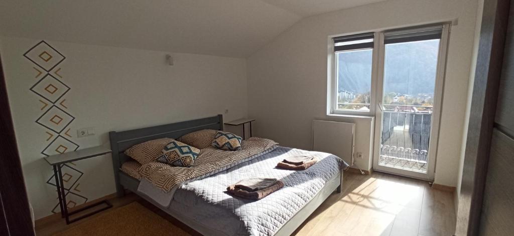 Un dormitorio con una cama y una ventana grande. en Legit House, en Yaremche