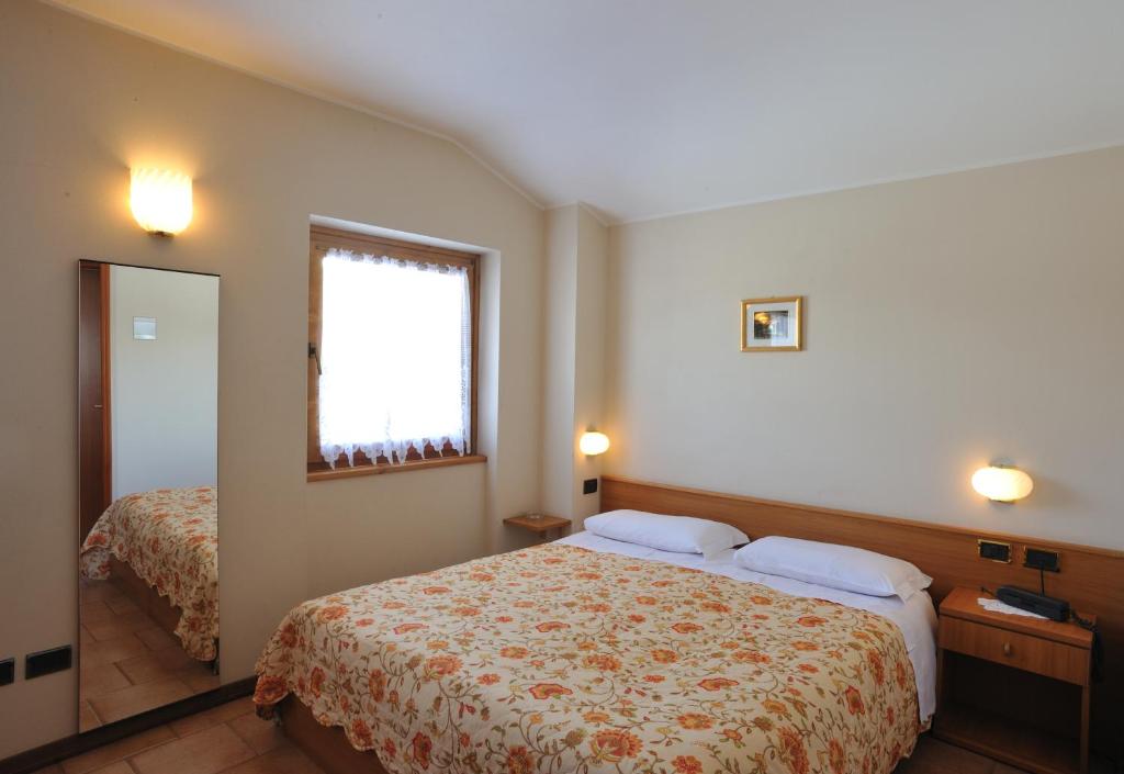 a hotel room with a bed and a window at Hotel Ristorante San Pietro in Valdisotto