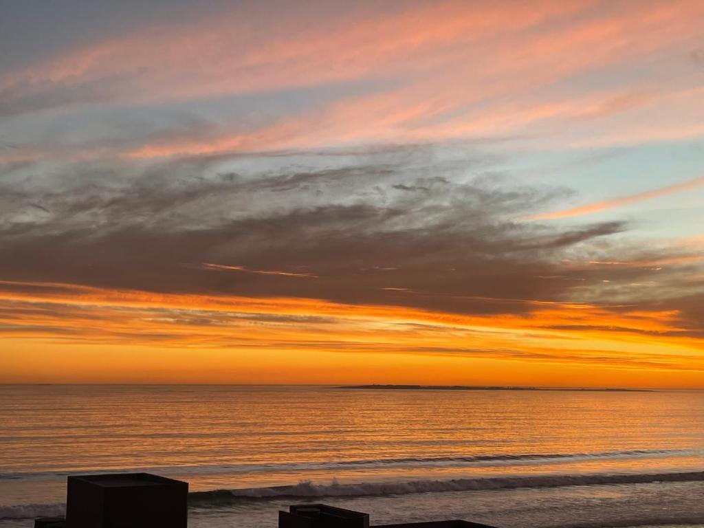 a sunset on a beach with the ocean at Ocean View B1001 in Bloubergstrand