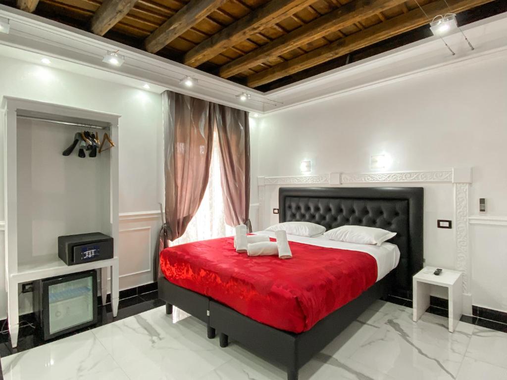 - une chambre avec un grand lit et une couverture rouge dans l'établissement Relais Parlamento, à Rome