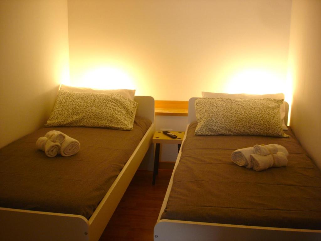 2 letti con asciugamani in una stanza di Fikus APT relax Castello Ursino a Catania