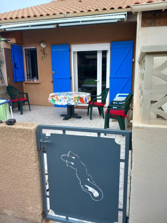 a sign in front of a patio with a table and chairs at La grande bleue in Port Leucate