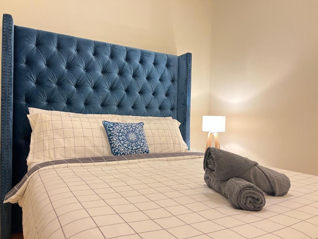 1 dormitorio con 1 cama grande y cabecero azul en Cosy 4BR Home 15 Minutes Away From Melbourne Airport, en St Albans