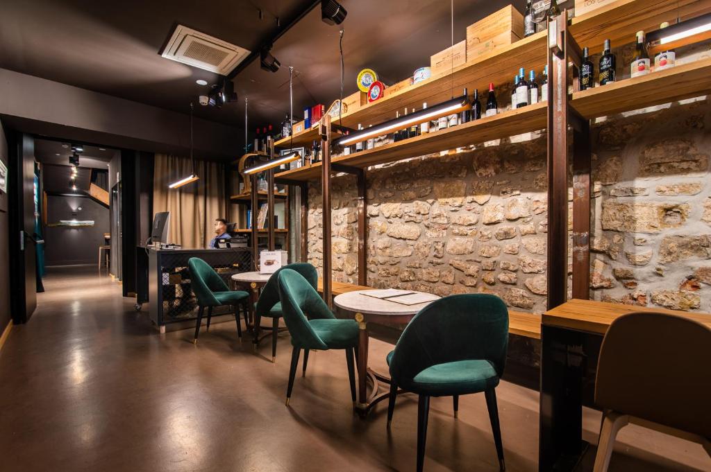 a restaurant with green chairs and tables and a counter at Hotel Atari in Donostia-San Sebastián