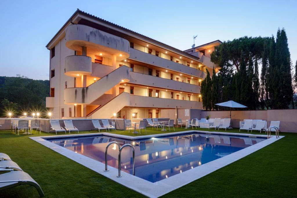 un hotel con piscina frente a un edificio en Tossa dreams, en Tossa de Mar