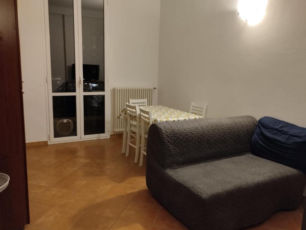uma sala de estar com um sofá e uma mesa em Montenero House em Bolonha