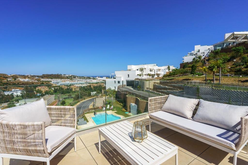 a balcony with two chairs and a table and a pool at Penthouse Banderas with own pool in La Cala de Mijas