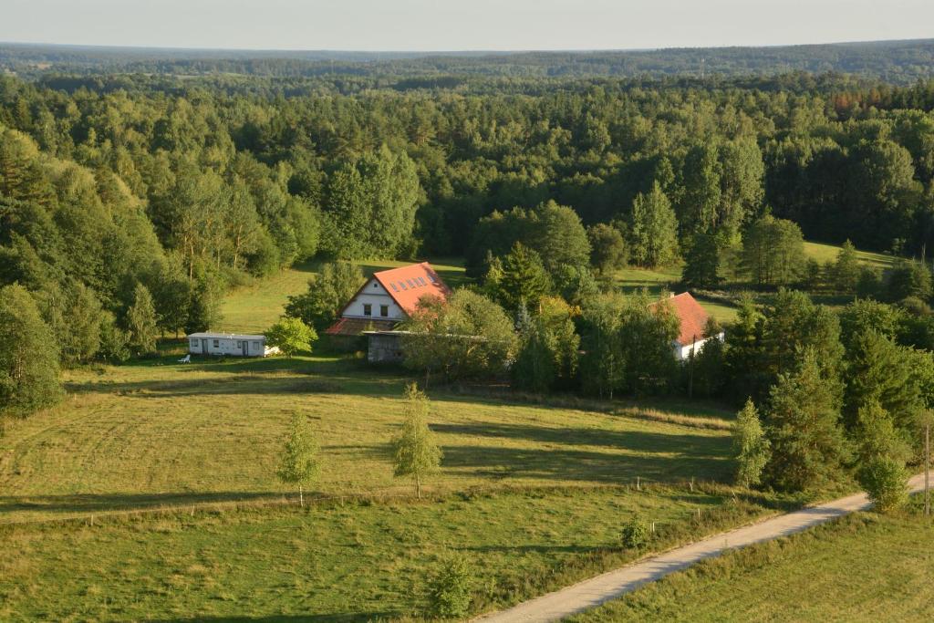a house in the middle of a field with a road at Klarysewo bliżej Słońca in Mrągowo