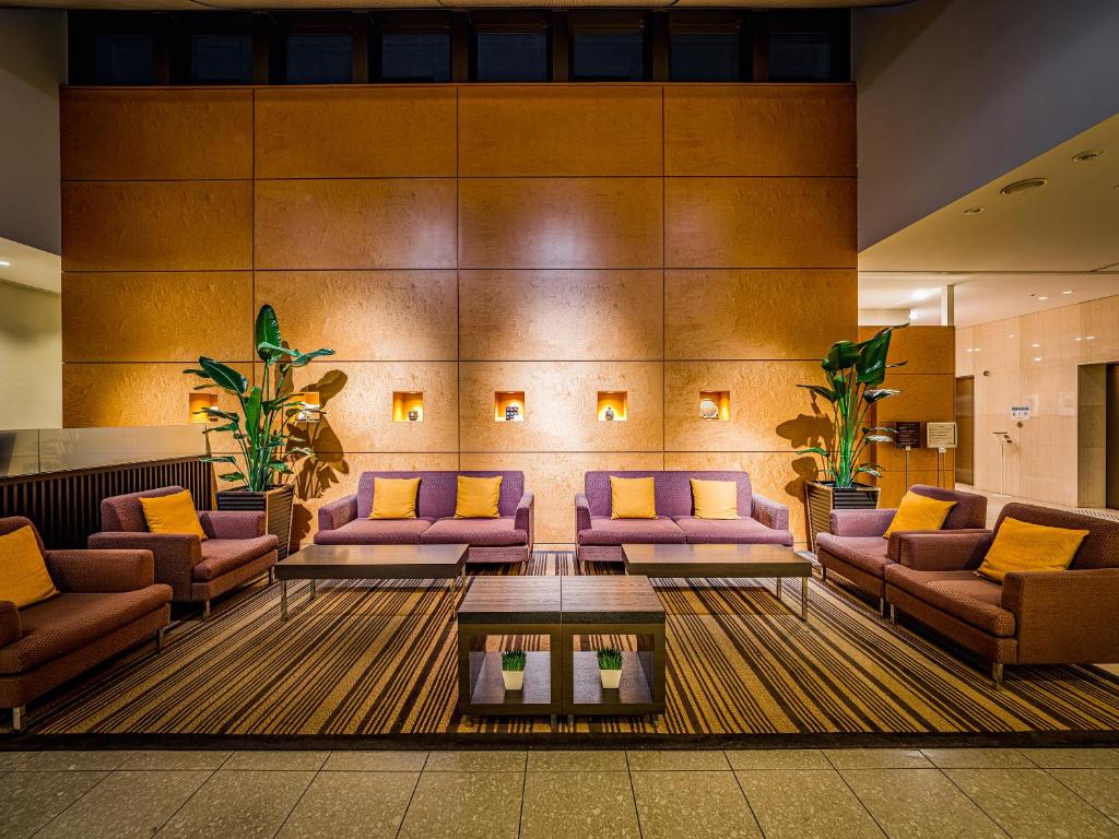 a lobby with purple couches and a coffee table at Mitsui Garden Hotel Okayama in Okayama