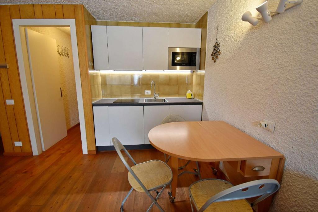 een keuken met een tafel en stoelen en een wastafel bij Spinale del Sogno in Madonna di Campiglio