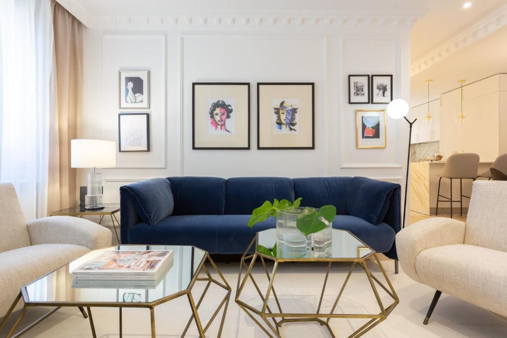 a living room with a blue couch and a table at Exclusiva vivienda en la Calle Jorge Juan in Madrid