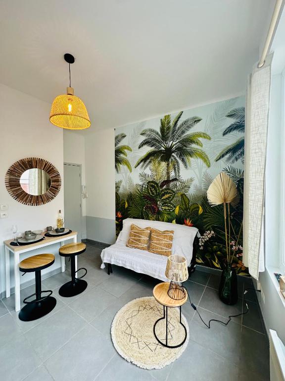 een slaapkamer met een bed met een muurschildering van palmbomen bij Studio Bohème hypercentre in Amiens
