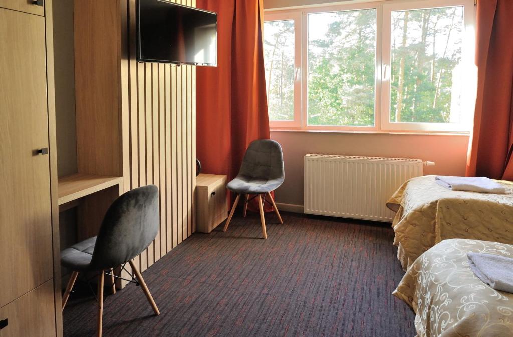 a hotel room with two chairs and a bed and a television at HOTEL MOTEL S5 in Bydgoszcz