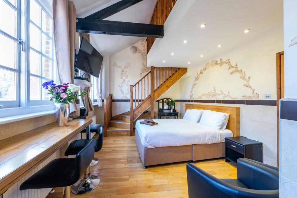 um quarto de hotel com uma cama e uma escada em Berkley Apartments em Londres