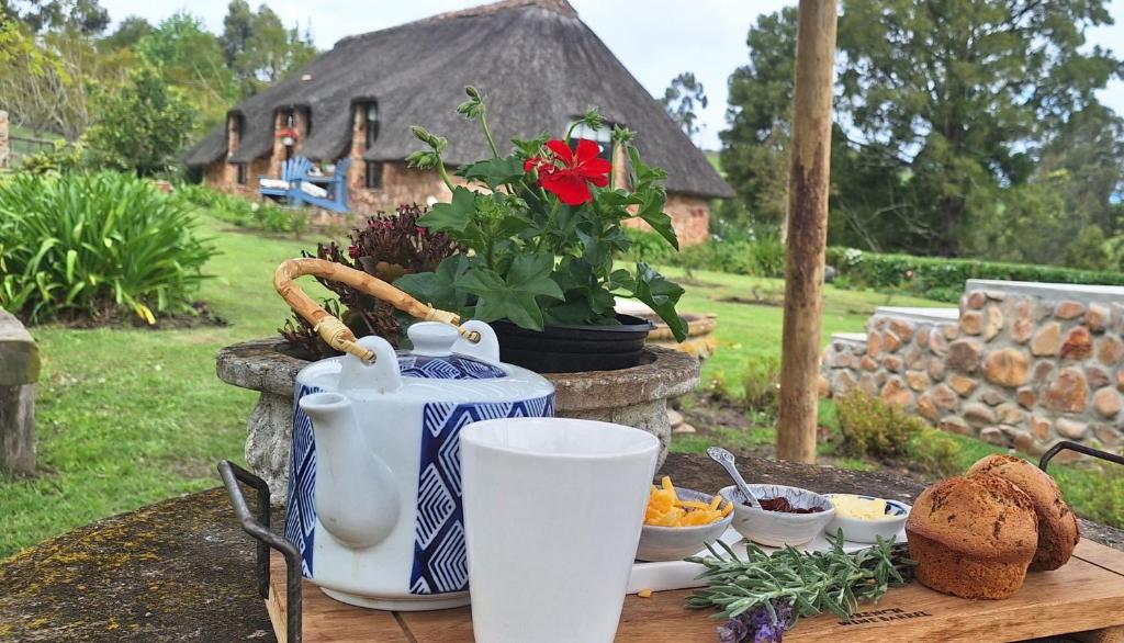 a table with a tea pot and some food on it at Prospect Farm Cottages in George