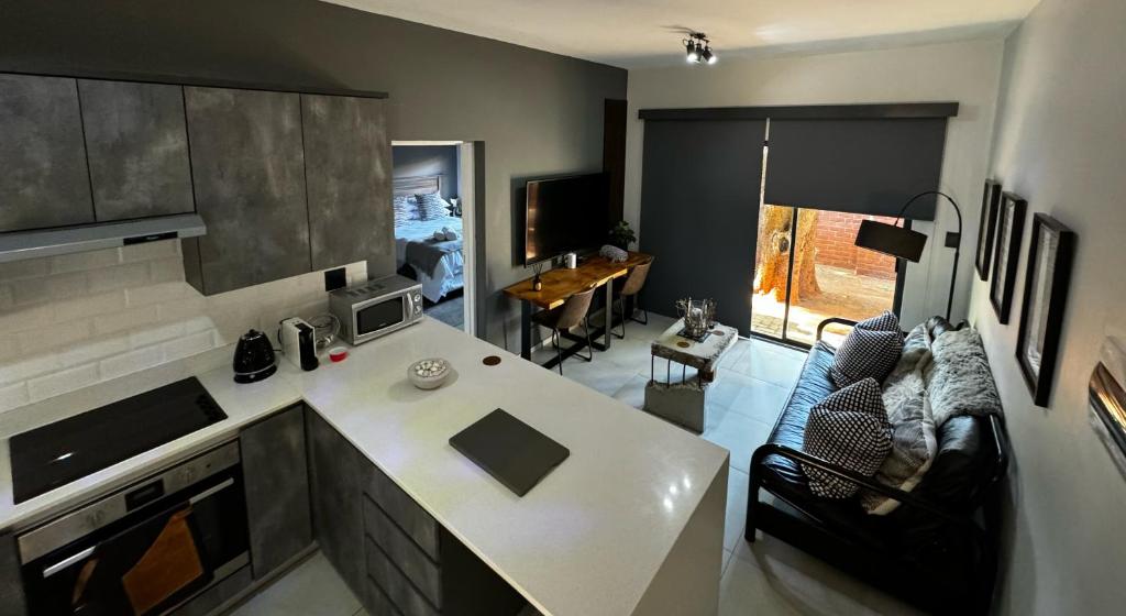 a kitchen and living room with a white counter top at Rand Corner Crib in Pretoria
