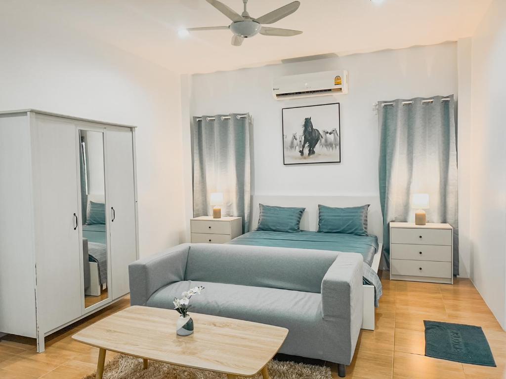 een woonkamer met een bank en een bed bij Rawai Valley Resort in Rawai Beach