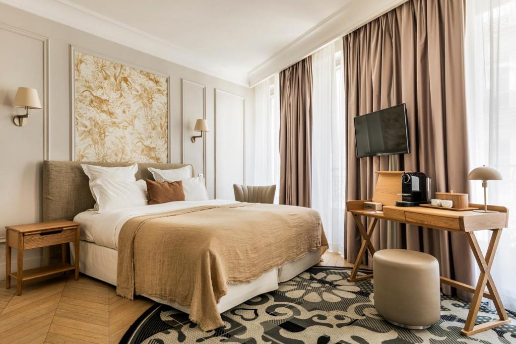 um quarto de hotel com uma cama e uma televisão em Maison Pigalle em Paris