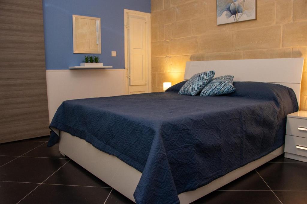 a bedroom with a blue and white bed with pillows at 139,Triq Aristarku, St Paul's Bay in St Paul's Bay