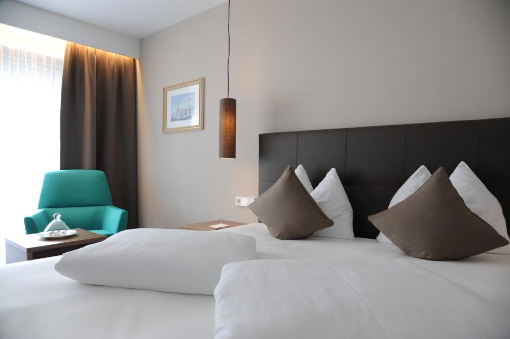 Postel nebo postele na pokoji v ubytování Hotel Vier Jahreszeiten