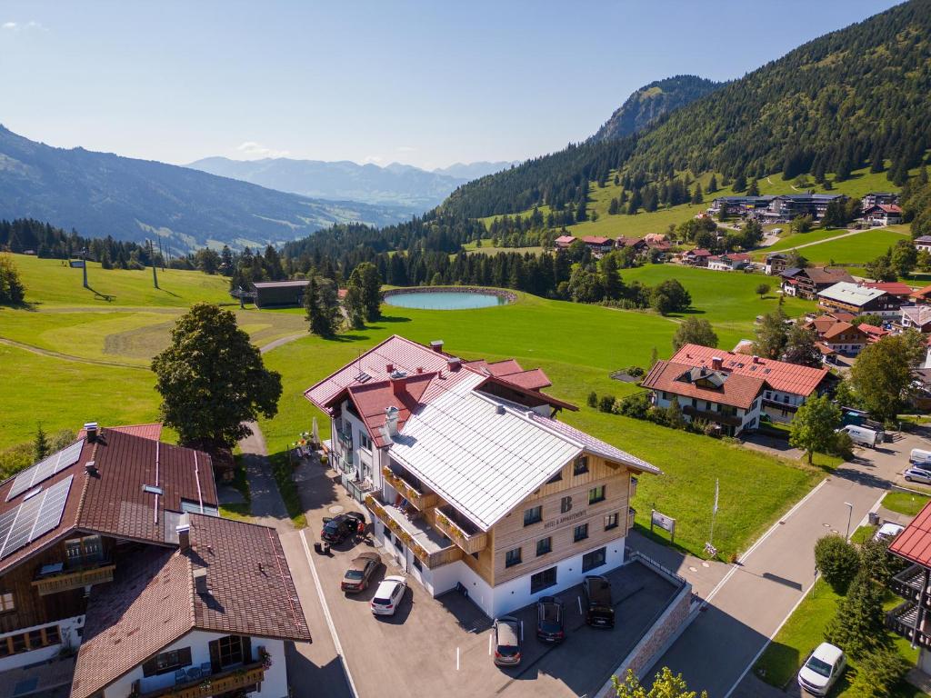 uma vista aérea de uma aldeia com uma casa e um campo em Bergzeit - Hotel & Appartements em Oberjoch