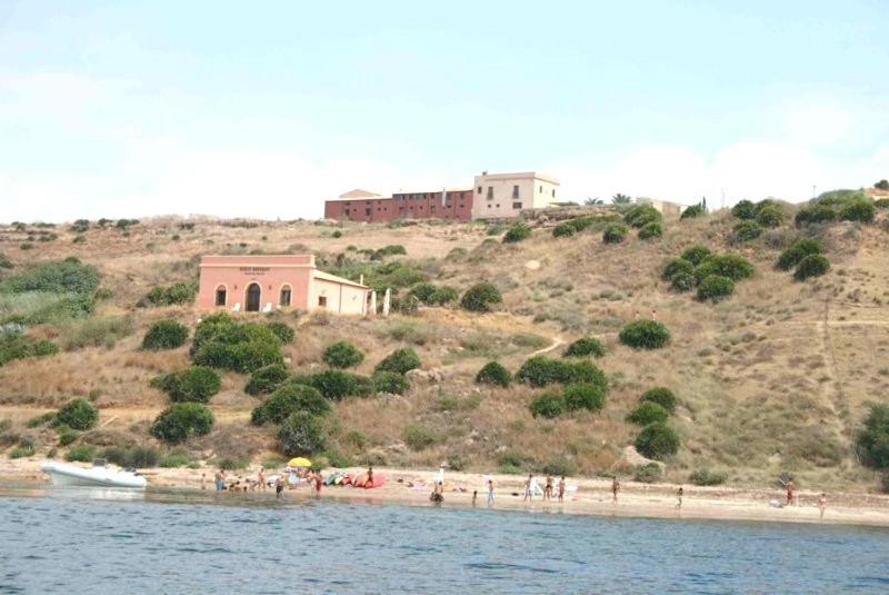 a group of people on a beach near the water at B&B Baglio Maragani in Maragani